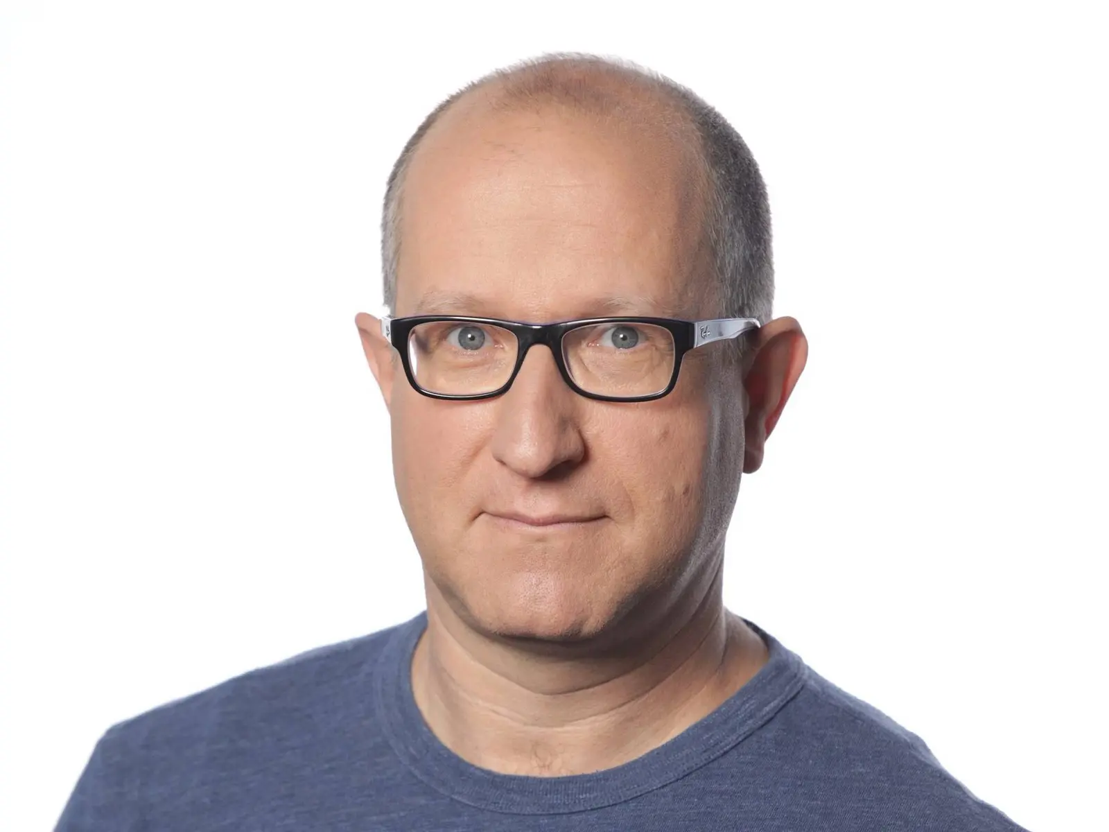Headshot of Eli Ben-Sasson wearing black glasses and a blue t-shirt against a white background