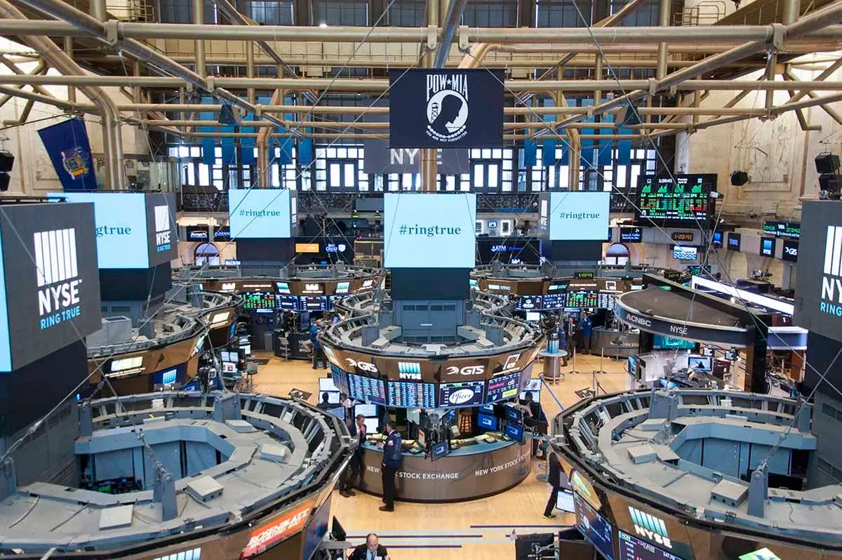 High-angle view of the New York Stock Exchange trading floor with trading posts, screens, and brokers.